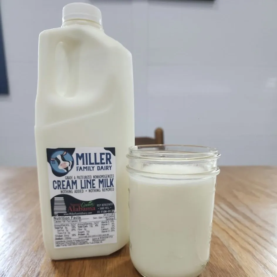Half gallon of Miller Family Dairy cream line milk next to a glass